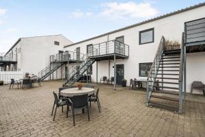 a patio with a table and chairs in front of a building at Well-Appointed Holiday Apartment With Panoramic Views Of Ebeltoft Vig in Ebeltoft