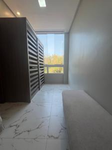 an empty room with a large window and a marble floor at Flat Paraíso da Praia 20324 in Santarém