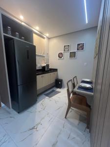 a kitchen with a black refrigerator and a table at Flat Paraíso da Praia 20324 in Santarém
