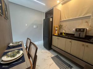 a kitchen with a table and a black refrigerator at Flat Paraíso da Praia 20324 in Santarém