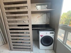 a laundry room with a washing machine and a ladder at Flat Paraíso da Praia 20324 in Santarém