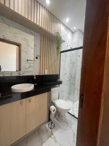 a bathroom with a toilet and a sink and a mirror at Flat Paraíso da Praia 20324 in Santarém