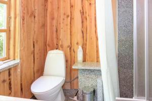 La salle de bains est pourvue de toilettes et d'un mur en bois. dans l'établissement Beautiful Home In Knebel With 2 Bedrooms, à Knebel 16 autres photos