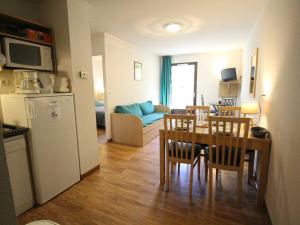 uma cozinha e sala de jantar com mesa e cadeiras em Charmant T2 avec balcon, parking et lave-linge près du parc - FR-1-313-235 em Luchon