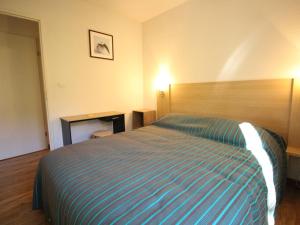 um quarto de hotel com uma cama e uma escrivaninha em Charmant T2 avec balcon, parking et lave-linge près du parc - FR-1-313-235 em Luchon