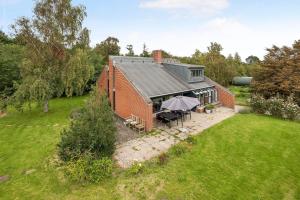 an aerial view of a brick building with an umbrella at Cozy House On Helgenæs in Knebel