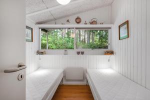 a small room with two beds and a window at Cozy Holiday Home In Beautiful Nature Near Ebeltoft in Ebeltoft