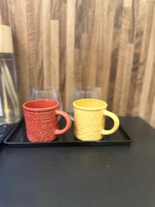 大阪市にあるe-hostel 心斎橋 404の黒いトレイの上に置かれた2つのコーヒーマグ +10枚の写真