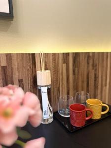 大阪市にあるe-hostel 心斎橋 404のカップとアルコールのボトルを入れたテーブル