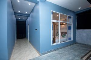 a room with a blue wall and a window at JK House Turtle Point in Dickwella