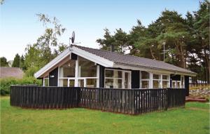 a house with a black fence in the grass at Holiday Home Røllikevej Knebel Ii in Knebel +20 photos