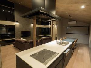 a kitchen and living room with a sink and a stove at Cosmique Chalet Hakuba in Hakuba +69 photos