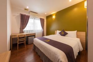 a bedroom with a bed and a desk and a window at Azumaya Hotel Kim Ma 2 in Hanoi +30 photos