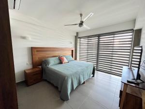 ヌエボ・バジャルタにあるNuevo Vallarta Condo nuevo y moderno a 5 min de playas PTRC17のベッドと大きな窓のある寝室