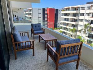 ヌエボ・バジャルタにあるNuevo Vallarta Condo nuevo y moderno a 5 min de playas PTRC17のバルコニー(椅子3脚、テーブル付)
