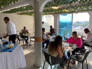 a group of people sitting at tables in a restaurant at ArisSha Boutique Hotel in Cali