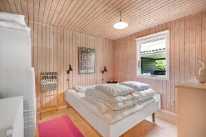 une chambre avec un lit avec des oreillers et une fenêtre dans l'établissement Well-Maintained Vacation Home Close To A Lovely Bathing Beach, à Ebeltoft