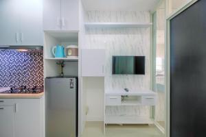 La cuisine est équipée d'un réfrigérateur et d'un évier. dans l'établissement New and Modern 1BR Apartment Atlanta Residences By Travelio, à Depok