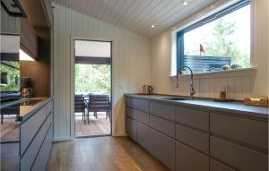 a kitchen with a sink and a large window at Lovely Home In Nexø With Kitchen in Neksø