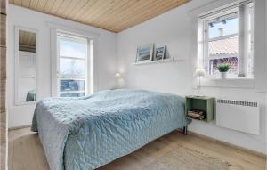 a white bedroom with a bed and two windows at Holiday Home Marielyst Strandpark Væggerløse Ii in Marielyst