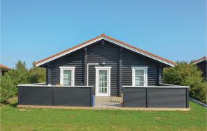 a black house with a wooden deck in front of it at Holiday Home Marielyst Strandpark Væggerløse Ii in Marielyst