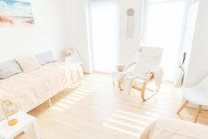 a white living room with a white couch and chairs at Ferienhaus Paradies in Naumburg