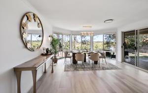 ゴールドコーストにある4BR Coomera Views! Prime Gold Coast Near Beachesのダイニングルーム(テーブル、鏡付)