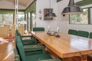 a dining room with a wooden table and green chairs at Amazing Home In Ebeltoft With 3 Bedrooms And Internet in Ebeltoft