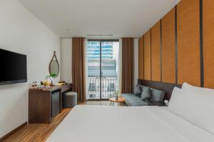 a hotel room with a large bed and a large window at Señorita Boutique Hotel in Da Nang