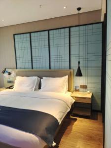 Postel nebo postele na pokoji v ubytování Echarm Hotel Xingyi Menglecheng Kratie Plaza