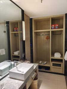 a bathroom with a sink and a mirror at Echarm Hotel Xingyi Menglecheng Kratie Plaza in Xingyin Wanfenglin Airport