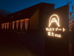 a neon sign on the side of a building at night at Wellリゾート富士 in Gotemba