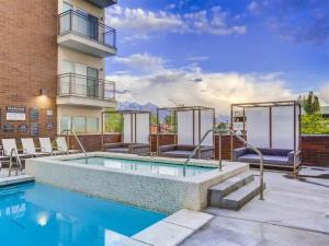 Una piscina con un patio y un edificio. en Luxury High-Rise Living in SLC, en Salt Lake City