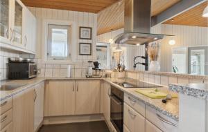 a large kitchen with wooden cabinets and a sink at Stunning Home In Vestervig With Sauna in Vestervig