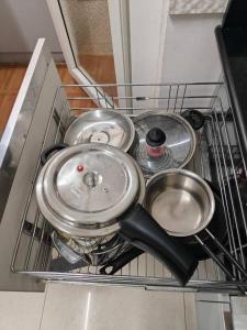 a pile of pots and pans sitting in a dishwasher at Modern 3BHK with Well-Equipped kitchen on 22 flr, Parking & Club House Perfect for Families in Bengaluru