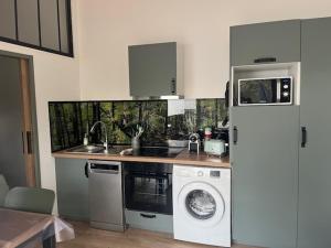 een keuken met een koelkast en een wasmachine bij Location havre de paix in Gourbera