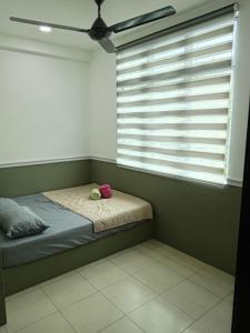 ein kleines Bett in einem Zimmer mit Fenster in der Unterkunft Hotel Seri Intan Tampin in Tampin