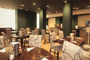 a dining room with wooden tables and chairs at The Stuart Hotel, Derby City Centre, Sure Collection by Best Western in Derby