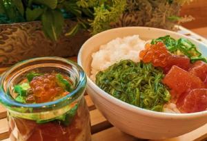 a bowl of food next to a bowl of vegetables at Dormy Inn Morioka in Morioka