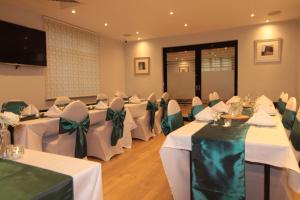 a banquet hall with white tables and green bows at The Stuart Hotel, Derby City Centre, Sure Collection by Best Western in Derby