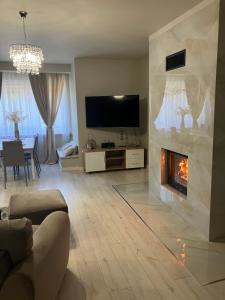 Televízia a/alebo spoločenská miestnosť v ubytovaní Apartamenty Arkadia