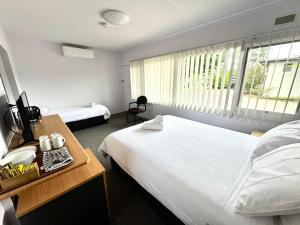 a hotel room with two beds and a window at Mount Beauty Motor Inn in Mount Beauty