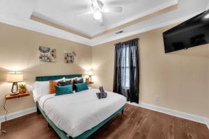 a bedroom with a large bed and a flat screen tv at Cozy 2B Townhouse - Hot Tub in Concord