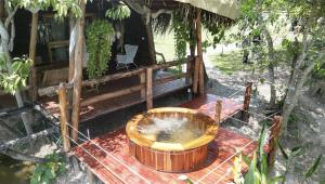 a wooden tub sitting on a deck in front of a house at wellgaya ecovillas in Villa Flor +33 photos