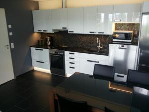 a kitchen with white cabinets and a black counter top at Koivuniemen Tila II in Säkylä +11 photos
