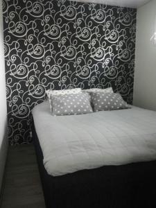 a bedroom with a bed with a black and white wall at Koivuniemen Tila II in Säkylä