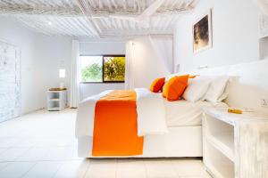 a white bedroom with an orange and white bed at Casa Zuri Diani Beach Villa in Diani Beach +66 photos