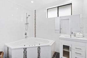 Beachside Palm Beach Luxury - 2 Bedroom Apartment في غولد كوست: حمام أبيض مع حوض استحمام ومغسلة +76 صورة