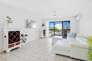 Beachside Palm Beach Luxury - 2 Bedroom Apartment في غولد كوست: غرفة معيشة مع أريكة بيضاء ومدفأة