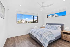 Beachside Palm Beach Luxury - 2 Bedroom Apartment في غولد كوست: غرفة نوم بيضاء مع سرير ونافذتين